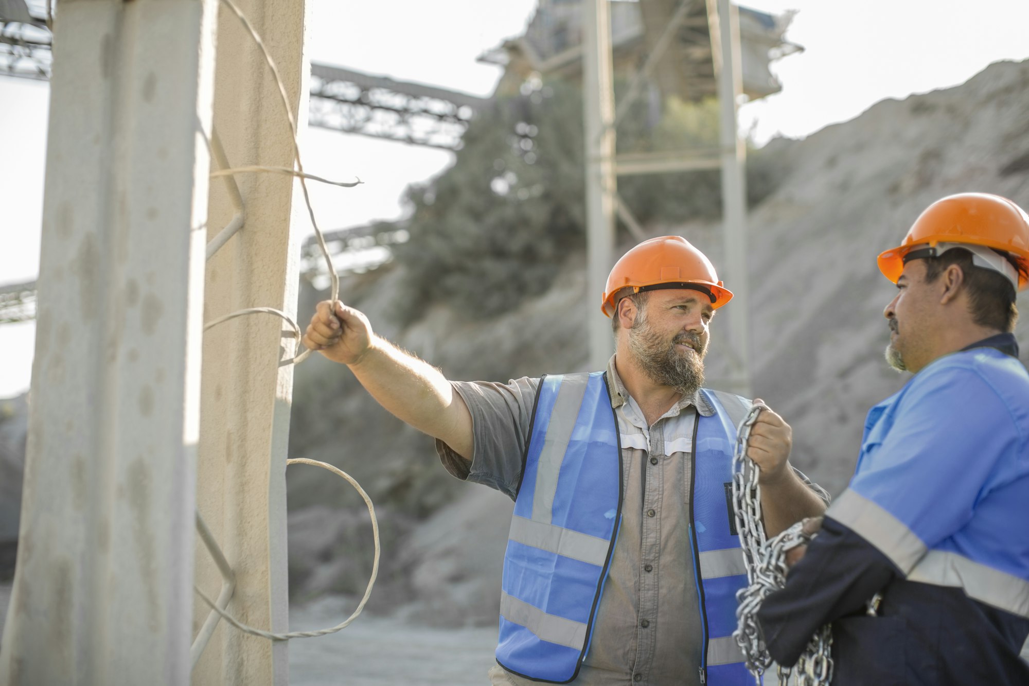 Two quarry workers in quarry, having discussion